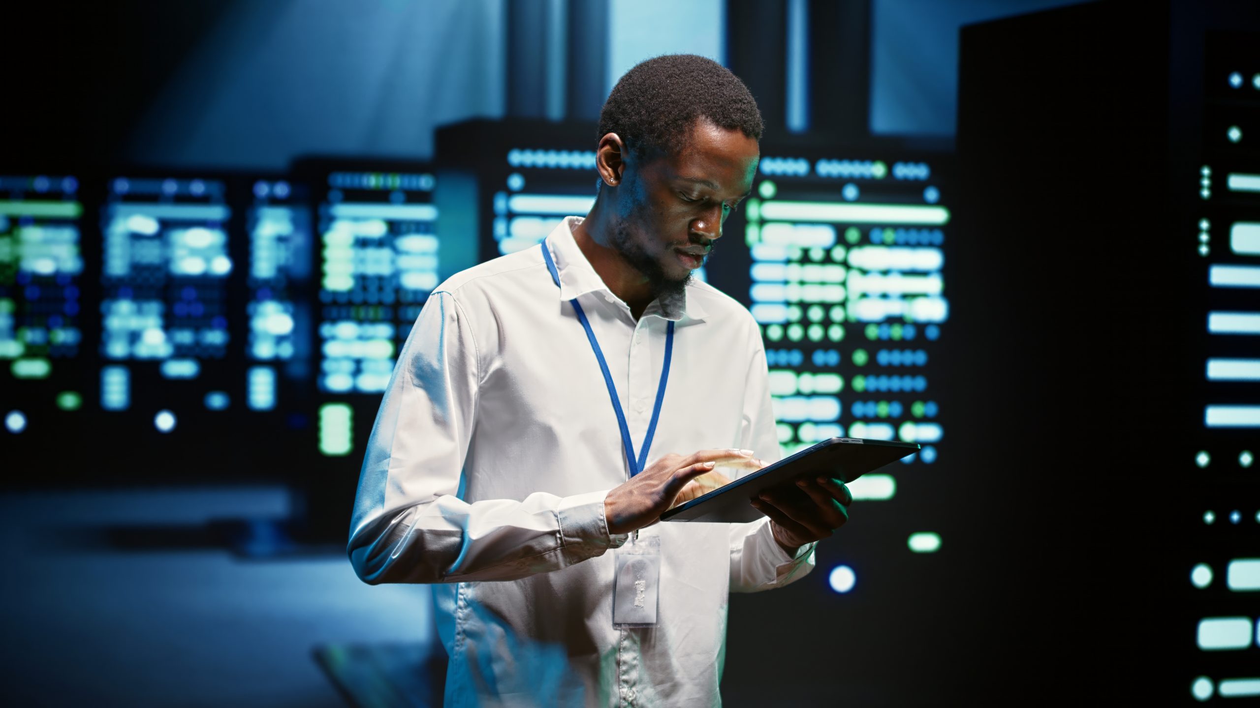 Technician in high tech facility walking through server rigs used for computationally intensive tasks such as molecular modeling or physical simulations. Specialist doing routine equipment maintenance
